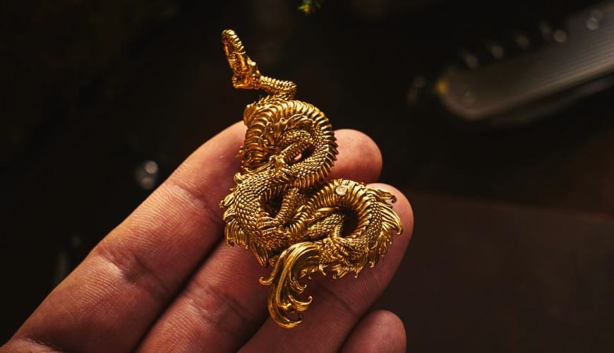 Laopu Gold golden dragon charm held in customer's hand