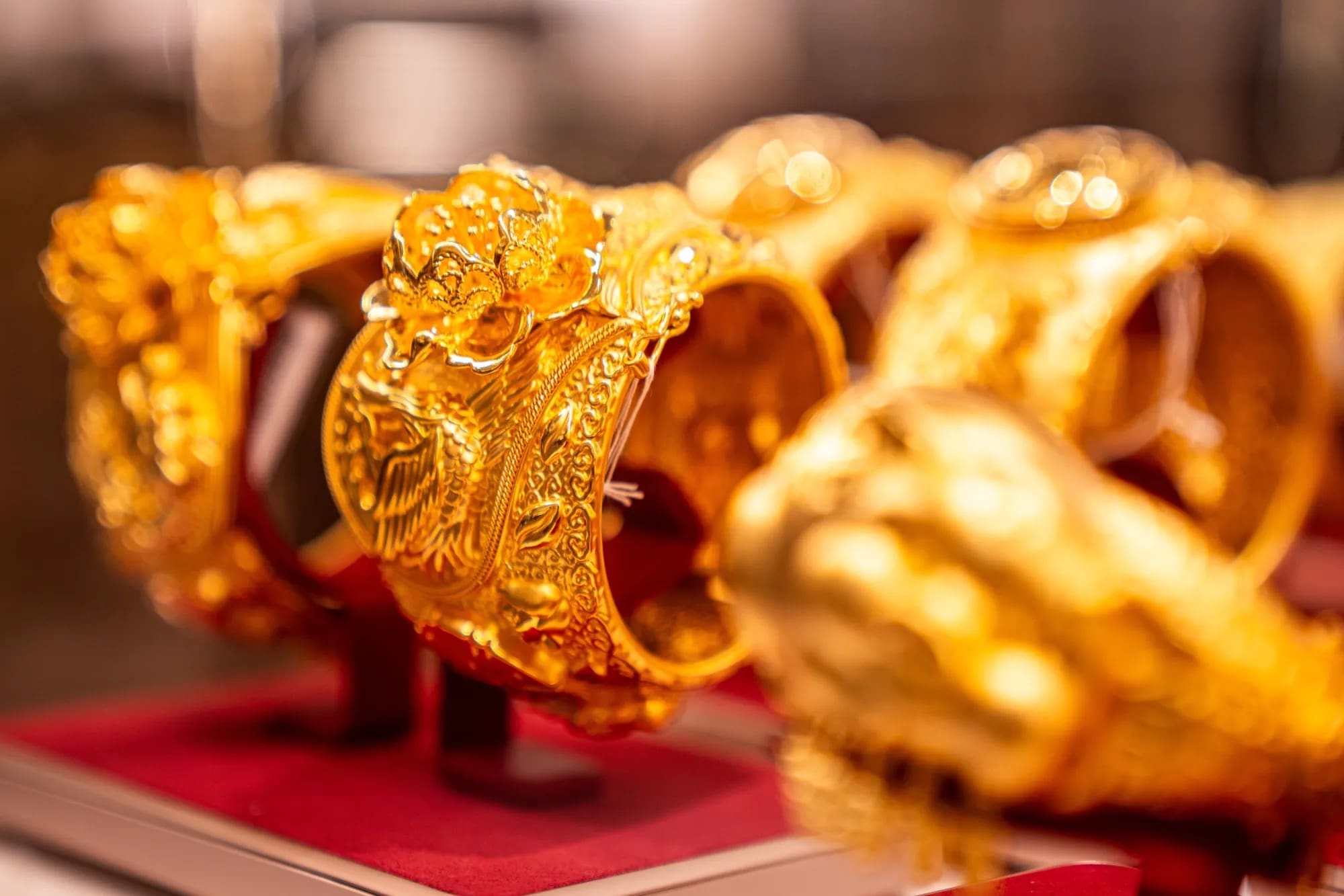 Golden Laopu Gold bracelets decorated with handcrafted Chinese art on display